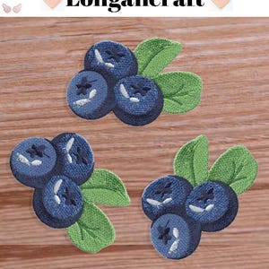May include: Three embroidered patches of blueberries with green leaves. The blueberries are blue with white stitching and the leaves are green.