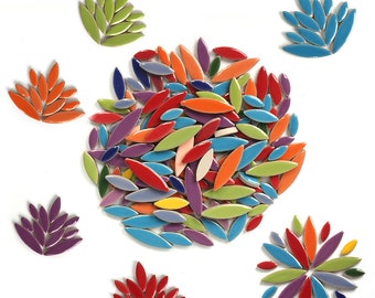 May include: A collection of colorful ceramic tile pieces in the shape of leaves. The tiles are arranged in a circle with a smaller cluster of tiles in the shape of a flower. The tiles are a variety of colors, including red, orange, yellow, green, blue, and purple.