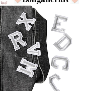 May include: A set of iron-on letters in a white and silver color scheme. The letters are in a varsity style font and include the letters X, R, V, M, E, D, and C.
