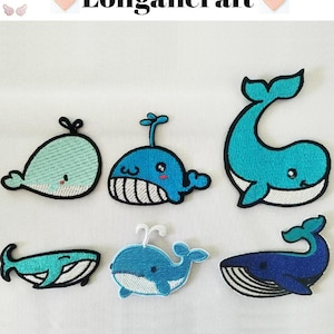 May include: A selection of six embroidered whale patches in various shades of blue and teal. Each patch has a unique design with detailed stitching and black outlines. The text "Longancraft" is displayed at the top of the image.