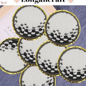 May include: Six white golf ball patches with black stitching and a gold border. The patches are arranged in a circle on a blue fabric background.