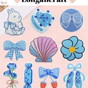 May include: A collection of embroidered patches in various shapes, including a bunny, heart, bow, seashell, and flower. The patches are primarily blue, with accents of pink, white, and yellow. The text "Longancraft" is at the top.
