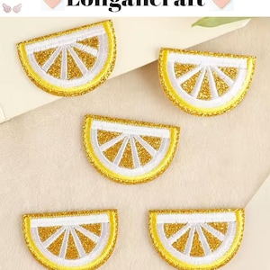 May include: Five gold glitter lemon slice iron-on patches. Each patch is a half-circle shape with a white outline and a yellow center.