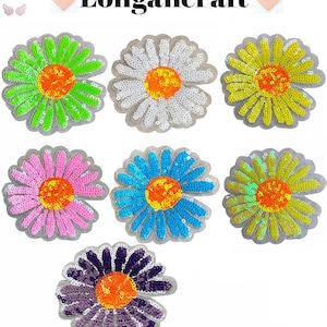 May include: Seven colorful daisy-shaped iron-on patches with sequins. The daisies are in shades of green, white, yellow, pink, blue, and purple. The centers of the daisies are orange.