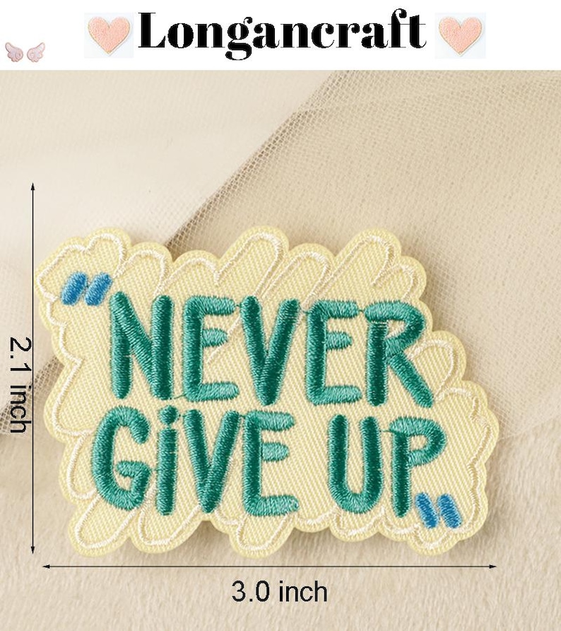 Pode incluir: Um remendo bordado amarelo com uma mensagem verde "NEVER GIVE UP". O remendo tem 7,6 cm de largura e 5,3 cm de altura.