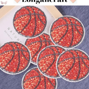 Op de afbeelding: Zeven rood-zwarte, strijkbare basketball-patches met pailletten. De patches zijn rond en hebben een witte rand.