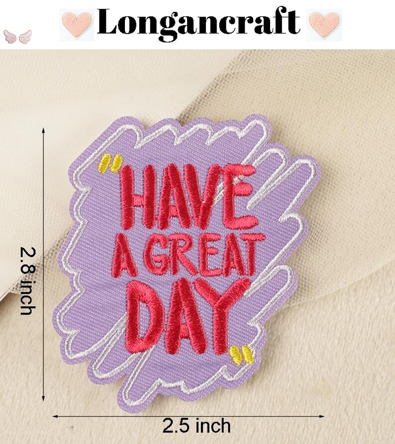 Pode incluir: Etiqueta bordada de ferro de cor roxa com contorno branco. A etiqueta diz "Have a Great Day" em letras cor-de-rosa. A etiqueta tem 2,5 polegadas de largura e 2,8 polegadas de altura.