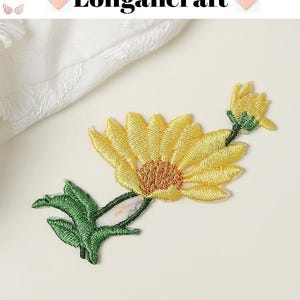 May include: Embroidered yellow daisy patch with green leaves and stem. The patch has a detailed design with a textured appearance. The text "Longancraft" is displayed at the top of the image.