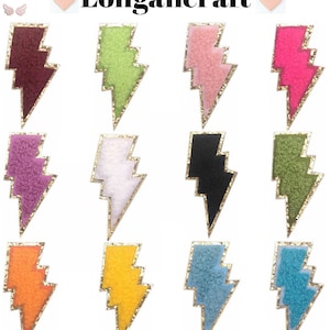 May include: Twelve iron-on patches shaped like lightning bolts in a variety of colours, including red, green, pink, purple, white, black, orange, yellow, blue, and teal. Each patch has a gold outline.