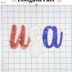 May include: USA spelled out in red, white, and blue sequins. The letters are in a cursive font and are on a white grid background.