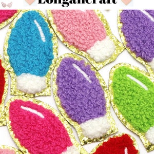 Peut inclure: Assortiment de patchs en forme d'ampoule de lumière moelleux et colorés avec une bordure dorée scintillante. Les patchs sont rose, bleu, violet, vert et rouge.