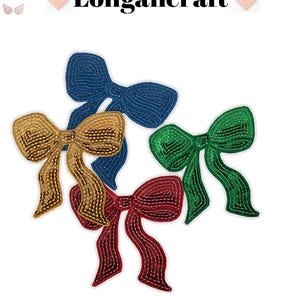 May include: Four decorative bow appliques in gold, blue, green, and red. The bows are made of a textured material and are arranged on a white background. The word "Longancraft" is displayed in black text above the bows.