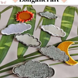 May include: Embroidered patches featuring weather-themed designs. The patches include a sun, clouds, and a moon with a star. The patches are in shades of gray, yellow, and orange. The brand name "Longancraft" is displayed at the top.