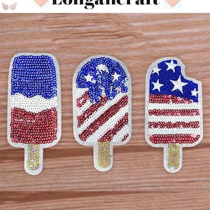 May include: Three iron-on patches shaped like popsicles with a red, white and blue American flag design. The patches are made of sequins and are perfect for adding a patriotic touch to clothing or crafts.