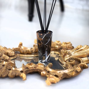 Può includere: Bottiglia diffusore in marmo nero e oro con canne nere su un vassoio decorativo dorato.