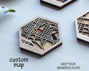 May include: Wooden hexagonal map of Colorado Springs, Colorado, with a red heart marking a location. The map is laser-cut with intricate street details. Text on the image reads "custom map" and "KEEP YOUR MEMORIES ALIVE!"