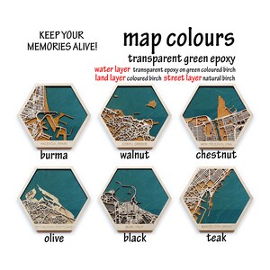Peut inclure: Six plaques hexagonales en bois avec diff&eacute;rentes cartes de villes et options de couleurs. Les couleurs sont Burma, Noyer, Ch&acirc;taigne, Olive, Noir et Teck. Le texte "map colours" est en haut de l'image. Le texte "transparent green epoxy" est sous le texte "map colours". Le texte "water layer transparent epoxy on green coloured birch" est sous le texte "transparent green epoxy". Le texte "land layer coloured birch street layer natural birch" est sous le texte "water layer transparent epoxy on green coloured birch".