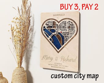 May include: A wooden custom city map in a heart shape, laser-cut with a detailed street layout. The map includes the names "Mary & Richard", a date, and coordinates for Washington, D.C. The text "MARRIED!" is at the top. The words "custom city map" are at the bottom.