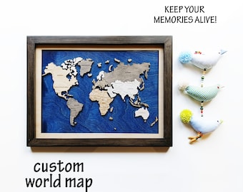 May include: A wooden world map with a blue background, framed in dark wood. The map is divided into continents and countries, with the names of each continent and country printed in white. The text "KEEP YOUR MEMORIES ALIVE!" is printed in black at the top of the image. The text "custom world map" is printed in black at the bottom of the image.