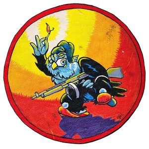 Peut inclure: Un écusson rond rouge, jaune et bleu avec un oiseau bleu de dessin animé tenant un fusil et une allumette allumée. L'oiseau porte un chapeau noir et a un cache-œil noir. L'écusson a un fond blanc et une bordure rouge.