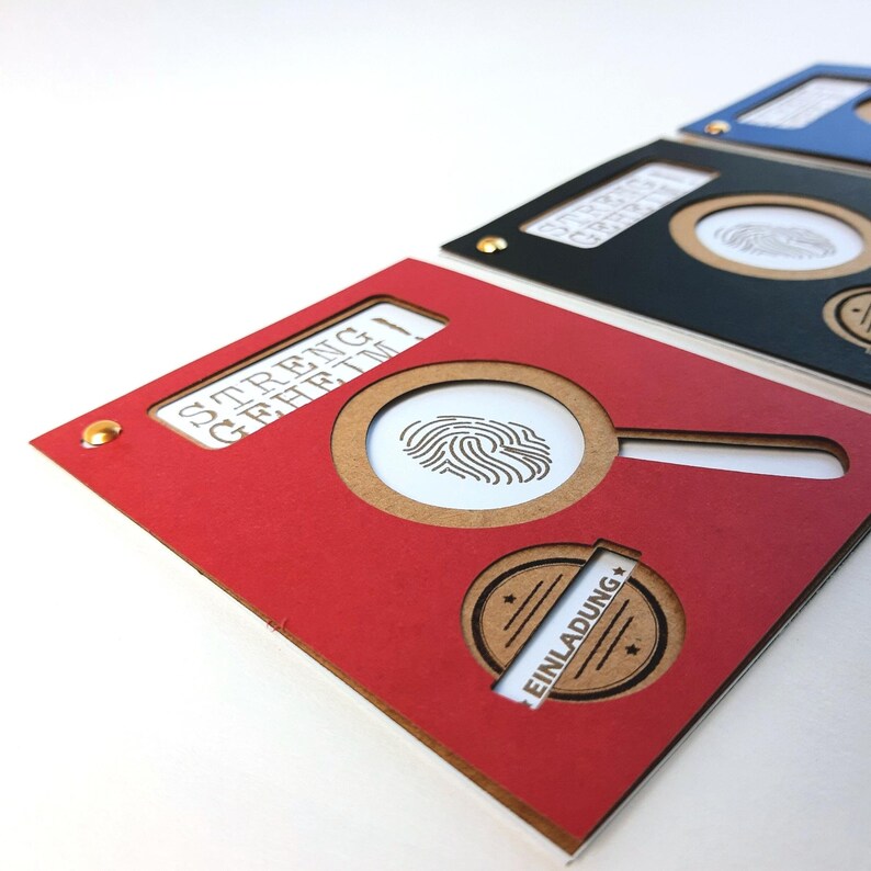 May include: Red card with a magnifying glass cutout revealing a fingerprint image. The card has the text "STRENG GEHEIM" and a brown circle with the text "EINLADUNG" in white.