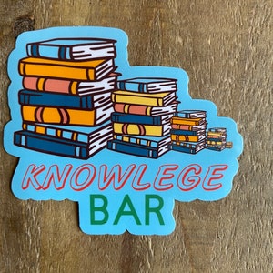 May include: A blue sticker with a stack of colorful books and the text "KNOWLEDGE BAR" in red and green.