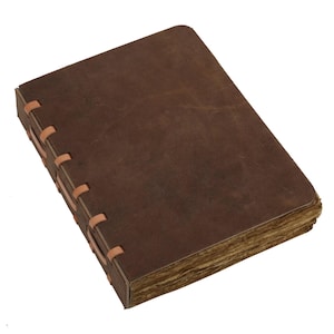 May include: A brown leather journal with a rectangular shape and a distressed look. The pages have an aged appearance, and the spine is hand-stitched with tan thread. The journal is closed, ready for use.