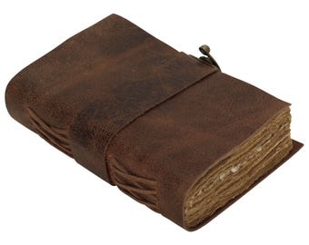 May include: A brown leather-bound journal with a clasp closure. The journal has a rustic, vintage look and is made of high-quality materials.