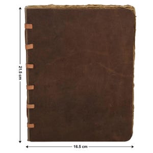 May include: A brown leather journal, measuring 21.5 cm x 16.5 cm, with a distressed, aged look. The cover is stitched with tan leather strips along the spine. The edges of the pages have a rough, uneven texture, enhancing the vintage feel.