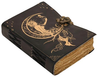 May include: Black leather journal with a gold embossed design of a mermaid sitting on a crescent moon. The journal has a clasp closure and is bound with black thread.