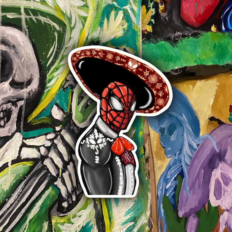 May include: A sticker featuring a cartoon illustration of Spider-Man dressed in a traditional Mexican mariachi outfit, wearing a large sombrero with red and white floral designs. The background is a colorful painting.
