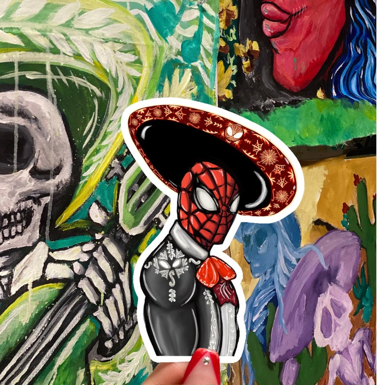May include: A sticker featuring a cartoon illustration of Spider-Man dressed as a mariachi. He is wearing a black suit with silver embroidery, a red bow tie, and a large sombrero with a red and gold design.