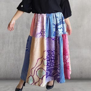 以下が含まれることがあります： 黒いトップスとパッチワークスカートの組み合わせ。 スカートはピンク、青、紫、ベージュなど、さまざまな色と柄が特徴です。 スカートはティアードデザインです。