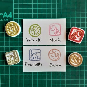 May include: Four colorful rubber stamps with Japanese characters and names written below each stamp. The names are Patrick, Noah, Charlotte, and Sarah.