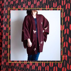 Peut inclure: Un kimono bordeaux à motifs géométriques et papillons brodés. Le kimono a un col en V et des manches longues.