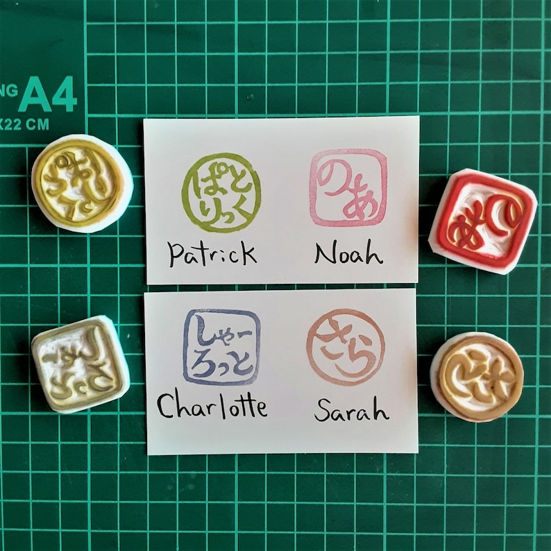 May include: Four colorful rubber stamps with Japanese characters and names written below each stamp. The names are Patrick, Noah, Charlotte, and Sarah.