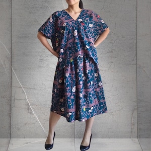 以下が含まれることがあります： ターコイズブルーとピンクの花柄のトップスとスカートのセット。トップスはVネックで半袖。スカートはミディ丈でゆったりとしたシルエットです。