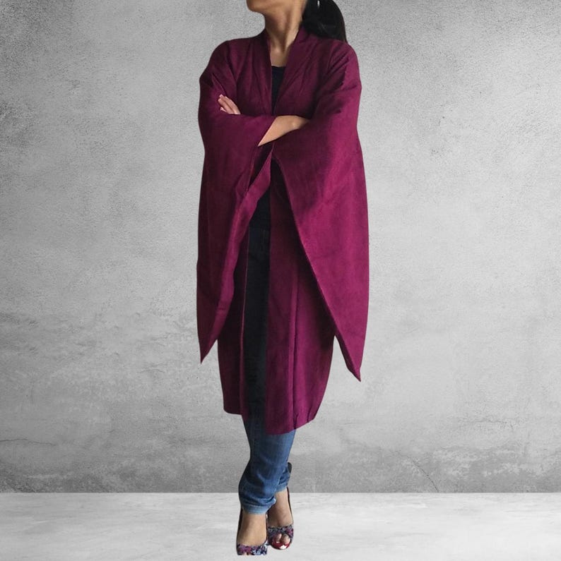 May include: A long, burgundy kimono-style cardigan with wide sleeves. The cardigan is open in the front and has a relaxed fit.