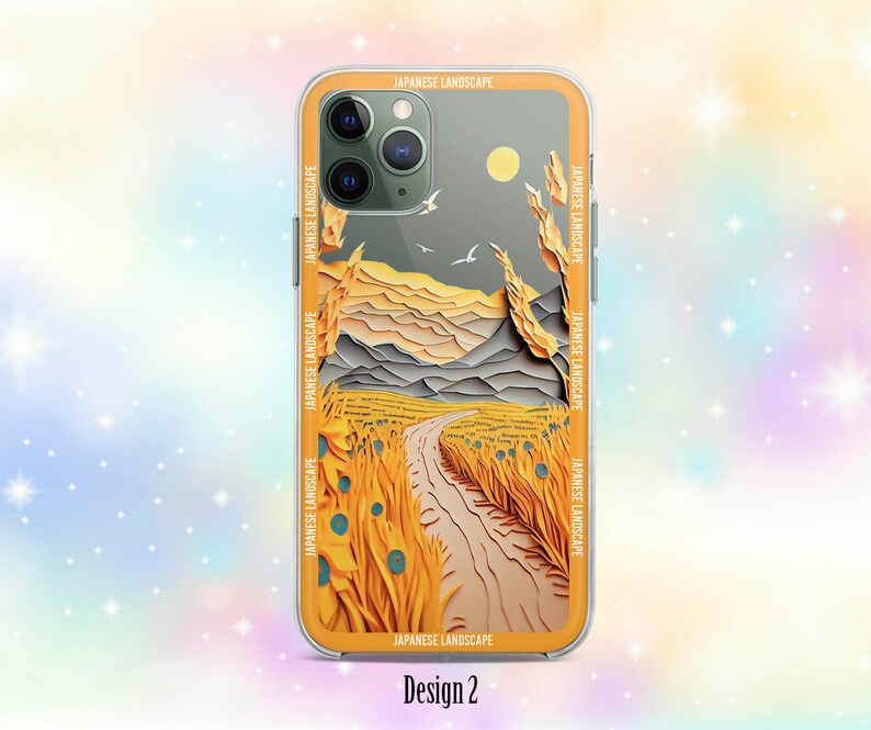 Op de afbeelding: Een telefoonhoesje met een Japans landschapsontwerp. Het ontwerp toont een pad dat door een veld met geel gras loopt, met bergen op de achtergrond. Het telefoonhoesje is transparant en heeft een zwarte rand.