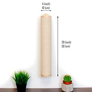 May include: A beige sisal scratching post for cats, mounted on a white wall. The post is 20 inches (50 cm) tall and 4 inches (10 cm) in diameter. There are two small potted plants on the floor below the post.