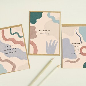 May include: Three birthday cards with abstract watercolour designs in pink, blue, and green. Each card has a kraft paper border and a different birthday message: "Have a Fabulous Birthday," "Birthday Wishes," and "Wishing You a Happy Birthday."