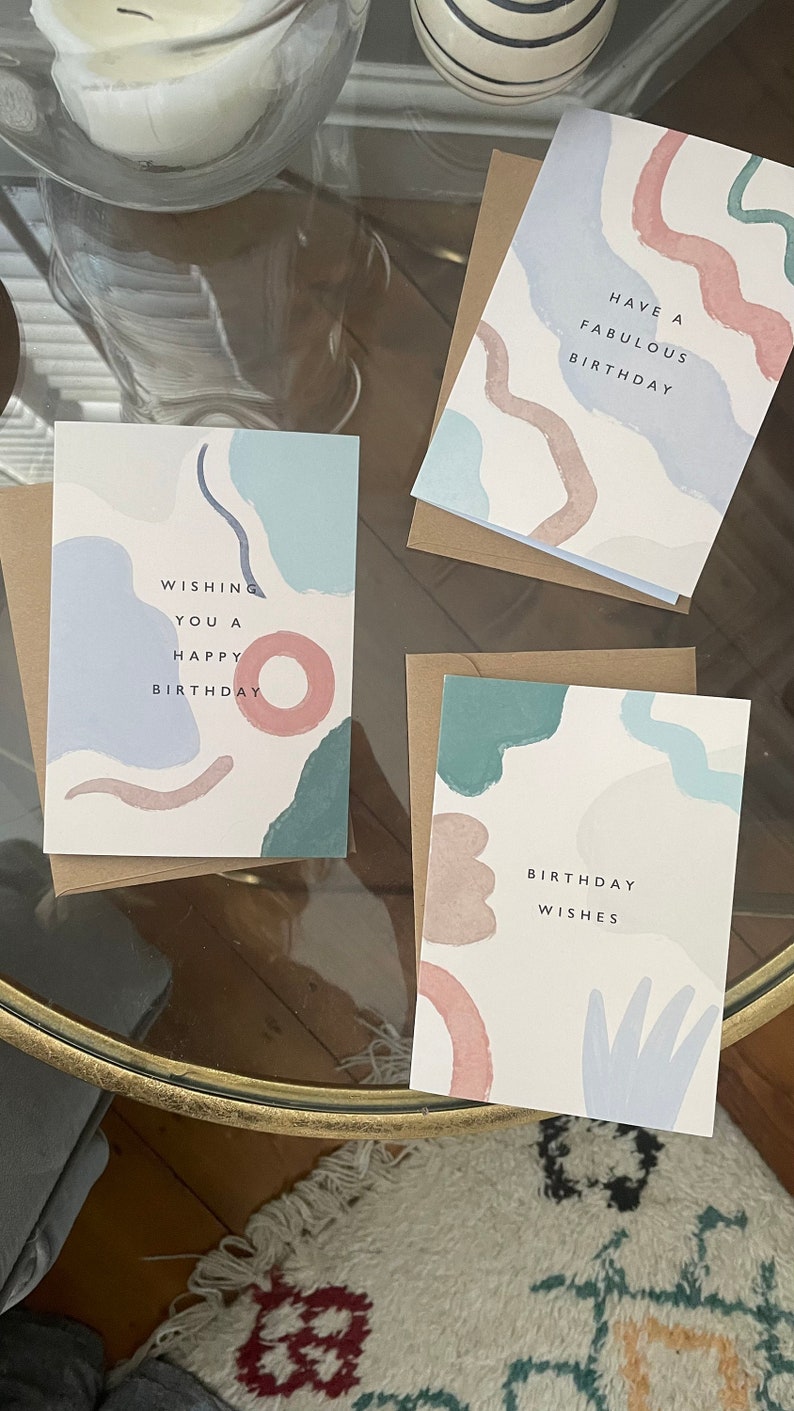 May include: Three birthday cards with abstract pastel designs. Each card features a different message: "Wishing you a happy birthday," "Have a fabulous birthday," and "Birthday wishes."