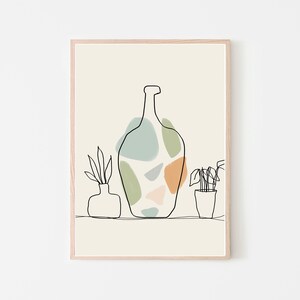 May include: Abstract art print featuring a large bottle shape with colourful, irregular shapes in green, blue, and orange. Two minimalist plant illustrations are on either side of the bottle. The artwork is framed in a light wood frame.