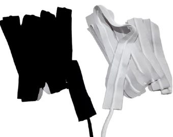 May include: Black and white zippers, labeled "1 1/2 INCH" and "MADE IN USA". The black zipper is folded, while the white zipper is in a loose, wavy arrangement. The zippers are likely for sewing or crafting projects.