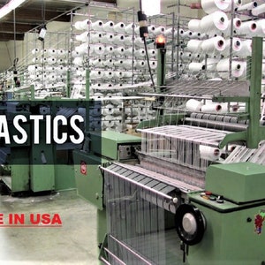 May include: A factory setting with multiple industrial machines weaving white elastic bands. The machines are green and have spools of white thread. The text "ELASTICS MADE IN USA" is visible in the image.