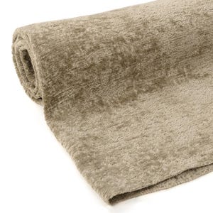 May include: A rolled-up, beige-colored rug with a textured surface. The rug is made of a soft, plush material and appears to be new. The neutral color and texture suggest it could be used in a living room or bedroom.