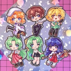 Peut inclure: Collection de six autocollants de personnages de style chibi. Chaque autocollant présente un personnage de style anime différent avec de grands yeux et des cheveux colorés. Les personnages sont vêtus de diverses tenues et tiennent différents objets.