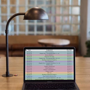 May include: A laptop computer screen displaying a class schedule with course names, assignment titles, and due dates. The schedule includes courses like BOOR 130, BOOR 330, ECON 200, and BOOR 360. The assignments include topics like "Investigating MIS", "Computer Hardware", and "Syllabus Quiz". The due dates are listed in the format MM.DD.YY.