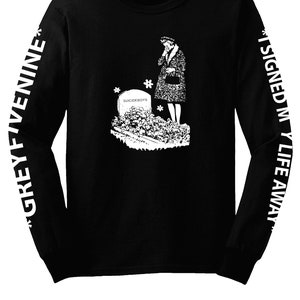 Puede incluir: Camiseta negra de manga larga con un gráfico blanco de una mujer de pie junto a una lápida que dice "Suicideboys". Las mangas tienen texto blanco que dice "Grey Five Nine" en la manga izquierda y "I Signed My Life Away" en la manga derecha.