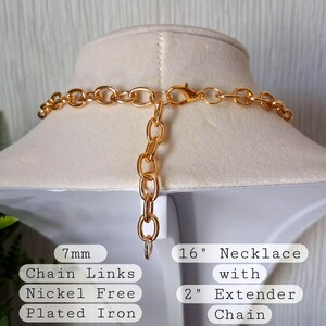 Pu&ograve; includere: Una collana color oro con una catena da 40.6 cm e un'estensione da 5 cm. La collana presenta maglie da 7 mm ed &egrave; realizzata in ferro placcato senza nichel. La collana &egrave; esposta su un manichino bianco.